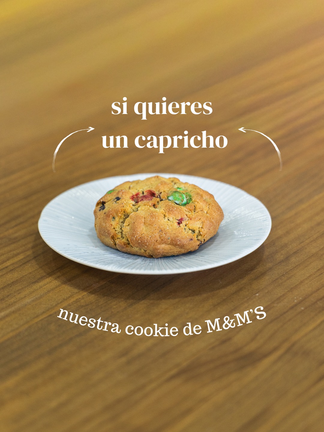 Cookie con piezas de chocolate de colores sobre plato blanco